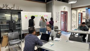 Stanford students working together at a whiteboard and desks
